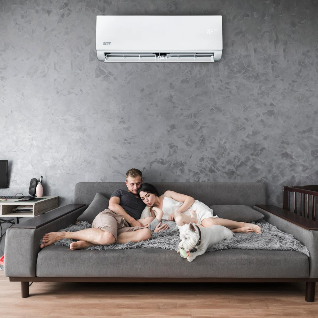 A couple sits together on a couch, comfortably enjoying their modern living space with an air conditioning system